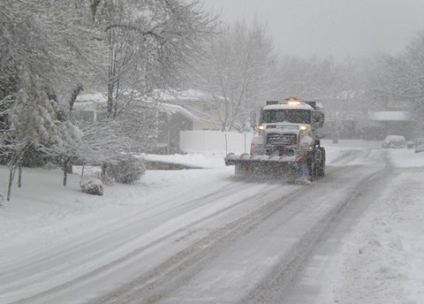 Un camión conduciendo por una carretera nevada.