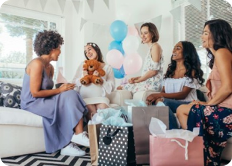 A group of women sitting on a couch with a teddy bear.
