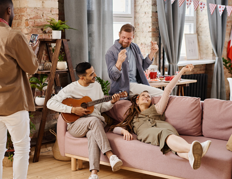 A group of people sitting on a couch playing instruments.