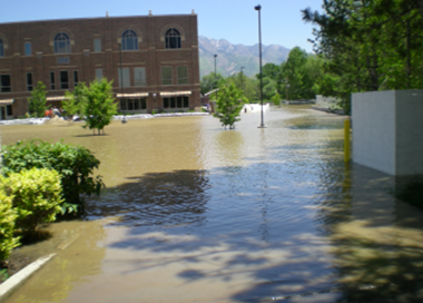A flooded street with a building in the background.