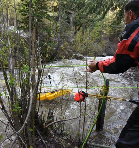 A man holding a cable and sampling water.