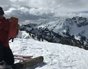 A man testing snow on a mountain.