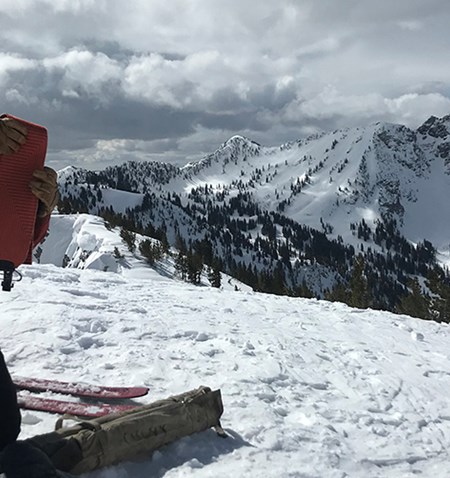 A man testing snow on a mountain.