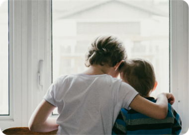 A person and a child looking at a window.