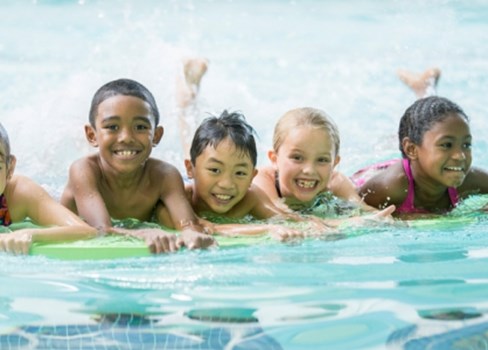 A group of kids in a swimming pool.
